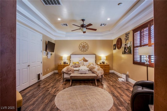 bedroom featuring ceiling fan, dark hardwood / wood-style floors, a tray ceiling, and crown molding