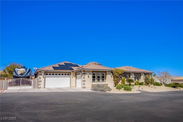 mediterranean / spanish house featuring a garage and solar panels