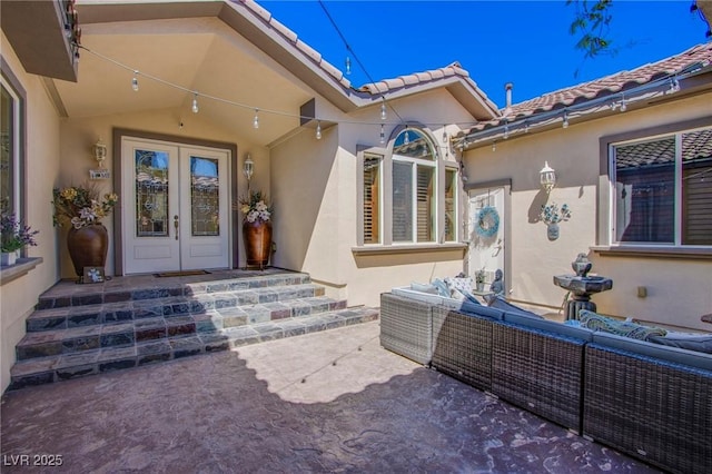 entrance to property with an outdoor hangout area, french doors, and a patio