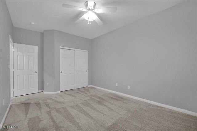 unfurnished bedroom featuring ceiling fan, a closet, and light carpet