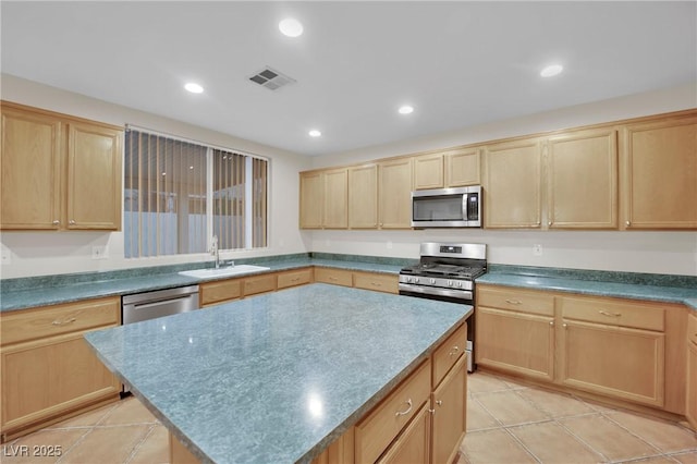 kitchen with sink, a center island, light brown cabinets, and appliances with stainless steel finishes