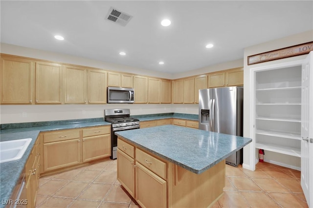 kitchen featuring appliances with stainless steel finishes, a center island, light brown cabinets, and sink