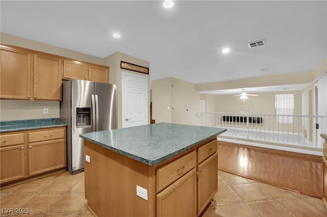 kitchen featuring a center island, ceiling fan, stainless steel fridge, and light tile patterned floors