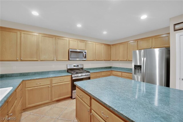 kitchen featuring appliances with stainless steel finishes, light brown cabinets, and light tile patterned floors