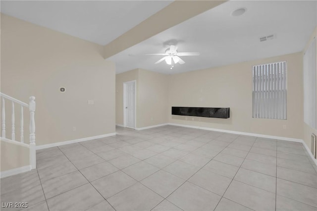 unfurnished living room with a fireplace, light tile patterned floors, and ceiling fan