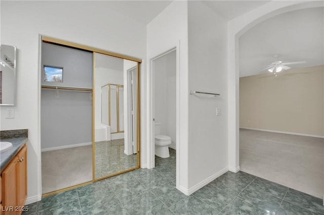 bathroom featuring vanity, toilet, and ceiling fan