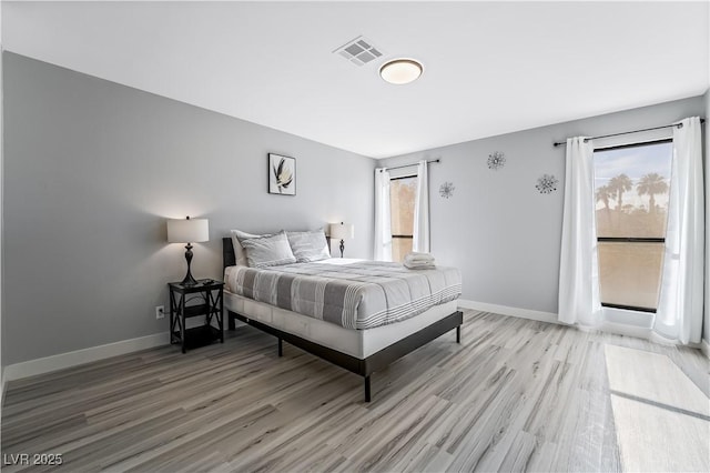 bedroom with wood-type flooring and multiple windows