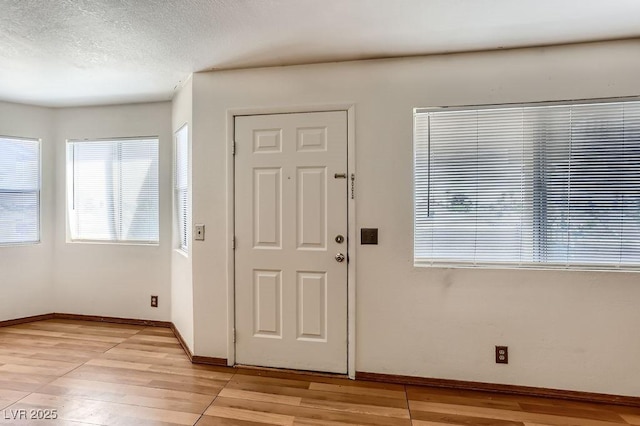 foyer featuring a textured ceiling and light hardwood / wood-style flooring