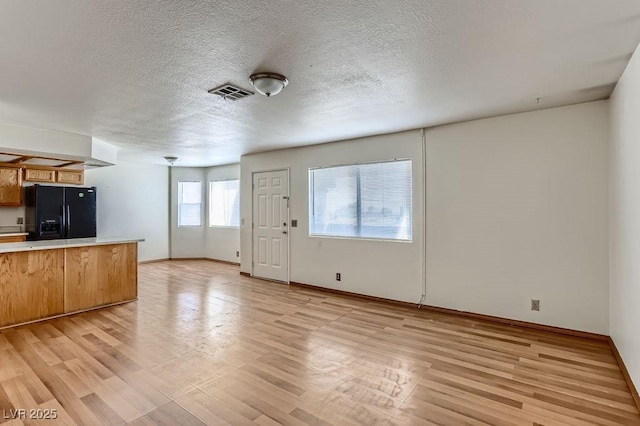 interior space with a textured ceiling and light hardwood / wood-style flooring