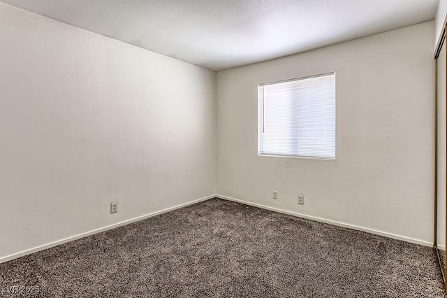 empty room with dark colored carpet