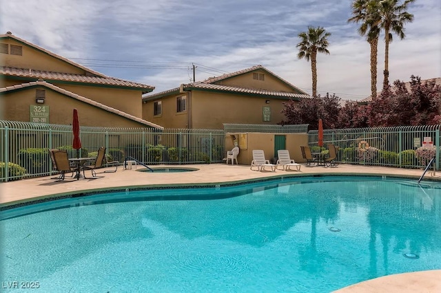 view of swimming pool featuring a community hot tub and a patio area