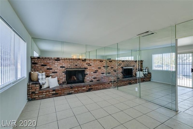 unfurnished living room with light tile patterned floors and a fireplace