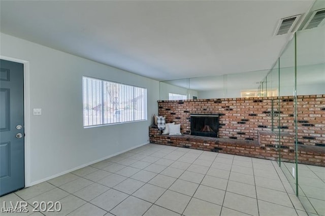 unfurnished living room featuring a fireplace and light tile patterned flooring