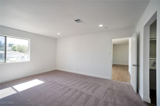 spare room featuring light carpet