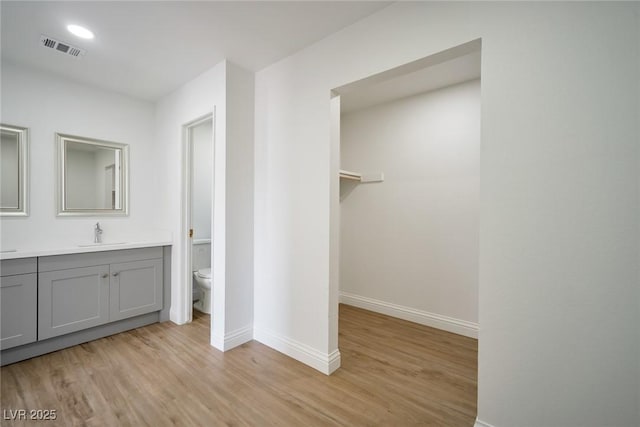 bathroom with vanity, toilet, and wood-type flooring