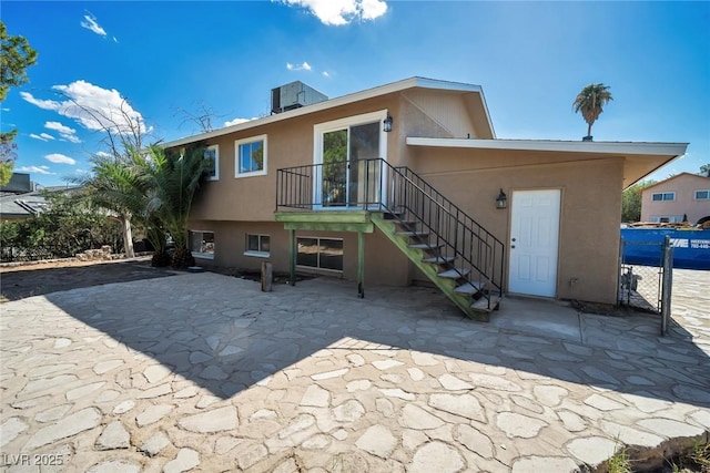 rear view of property with central AC unit and a patio