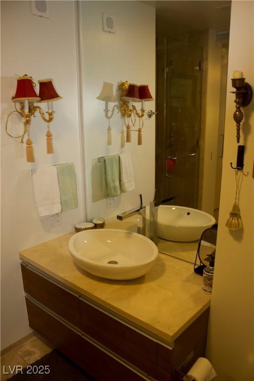 bathroom with a shower with door and vanity