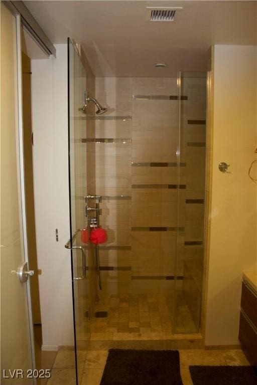 bathroom with tile patterned floors, vanity, and a shower with shower door