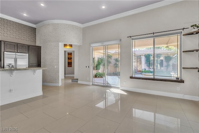 unfurnished living room featuring light tile patterned floors and crown molding