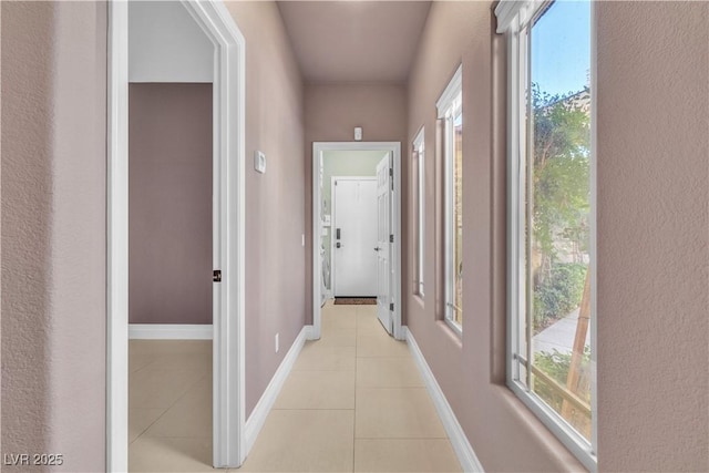 hall with plenty of natural light and light tile patterned floors