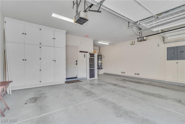 garage featuring electric panel, strapped water heater, and a garage door opener