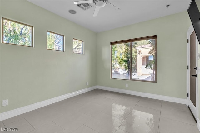 tiled empty room featuring plenty of natural light and ceiling fan