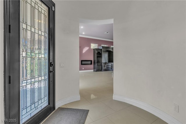 tiled foyer entrance with crown molding