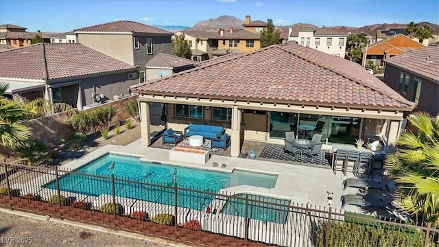 view of swimming pool featuring outdoor lounge area, a jacuzzi, a mountain view, and a patio