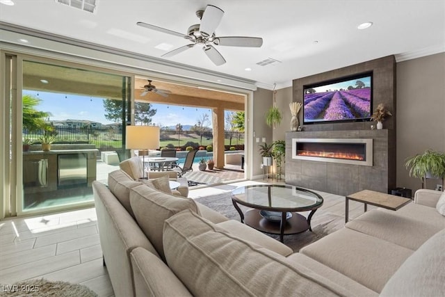 tiled living room featuring ceiling fan and crown molding