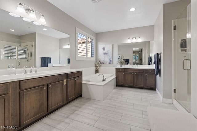 bathroom featuring vanity and independent shower and bath