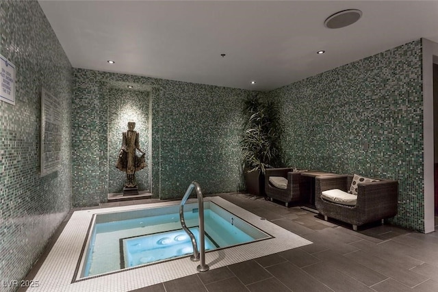 view of swimming pool featuring an indoor hot tub