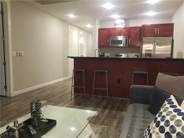 kitchen featuring stainless steel appliances, dark wood-type flooring, and sink