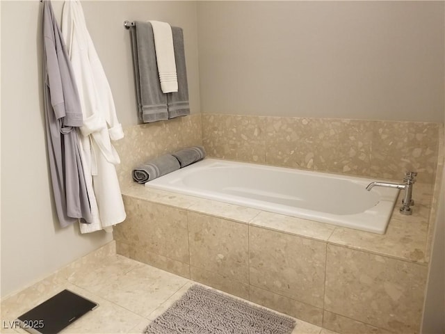 bathroom with tiled tub and tile patterned flooring