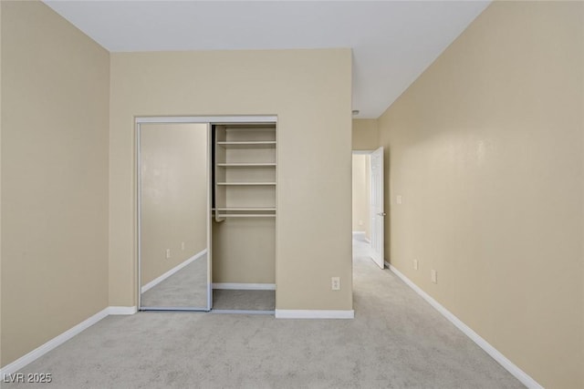 unfurnished bedroom with light carpet and a closet