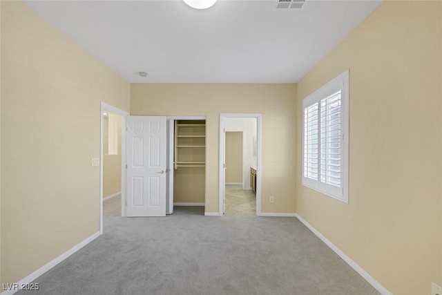 unfurnished bedroom with light carpet and a closet