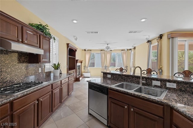 kitchen with backsplash, dark stone counters, sink, light tile patterned flooring, and stainless steel appliances