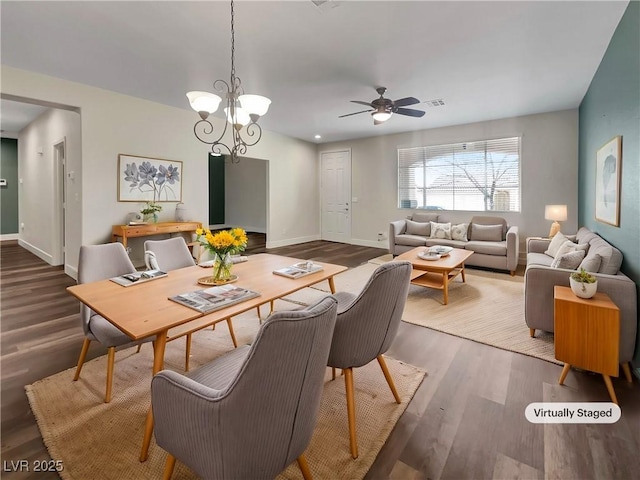 dining space with dark hardwood / wood-style floors and ceiling fan with notable chandelier