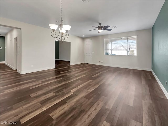 interior space featuring ceiling fan with notable chandelier and dark hardwood / wood-style floors