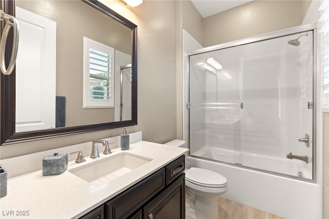 full bathroom with vanity, toilet, and combined bath / shower with glass door