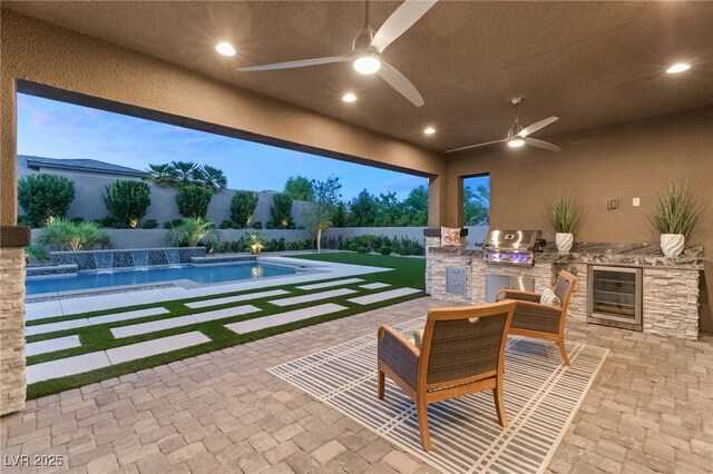 pool at dusk featuring pool water feature, a patio, area for grilling, and ceiling fan