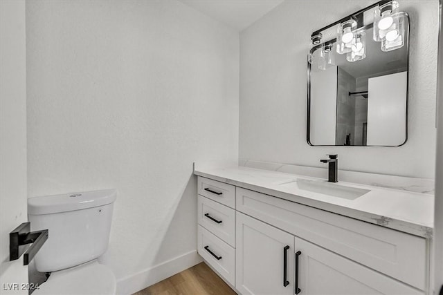 bathroom with wood-type flooring, vanity, and toilet