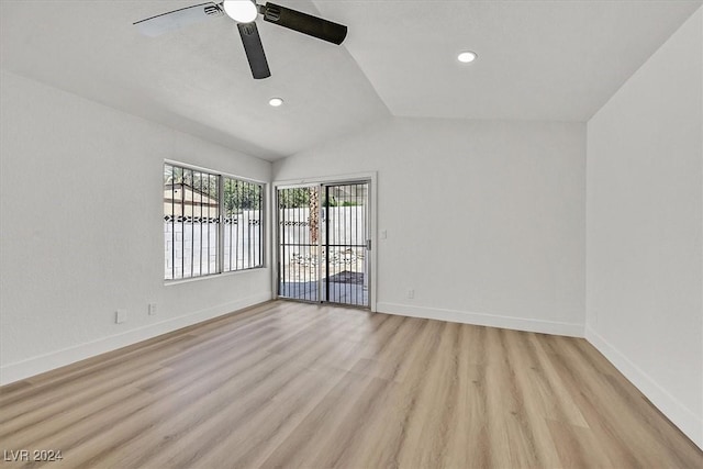 empty room with ceiling fan, light wood-type flooring, and vaulted ceiling