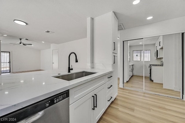 kitchen with a wealth of natural light, light stone countertops, sink, stainless steel appliances, and white cabinets