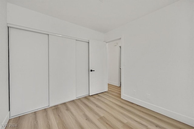 unfurnished bedroom with light hardwood / wood-style floors and a closet