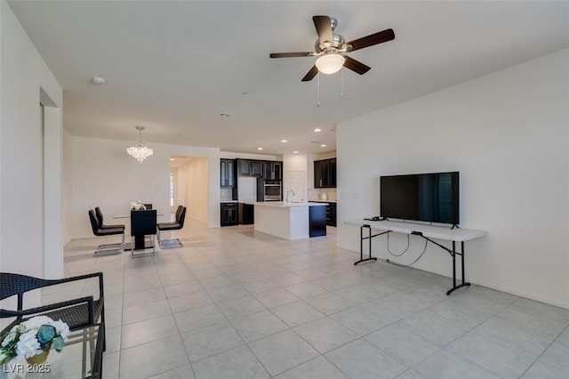 living room with light tile patterned floors, ceiling fan with notable chandelier, and sink