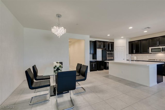 tiled dining room with sink and a notable chandelier