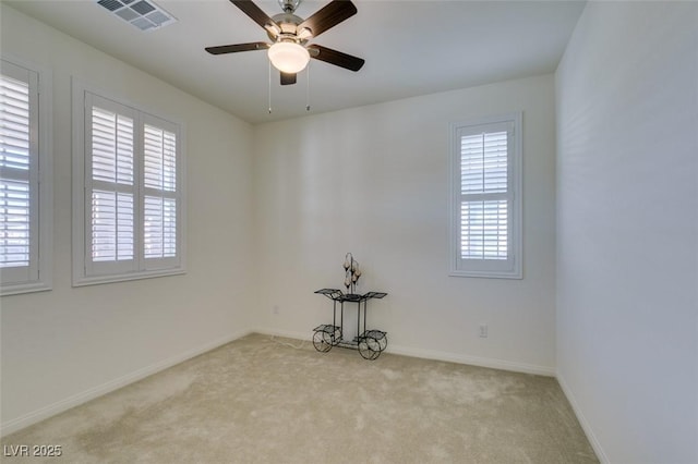 carpeted spare room featuring ceiling fan