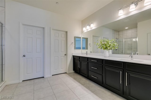 bathroom with a shower with door, vanity, and tile patterned flooring