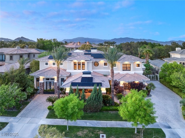 mediterranean / spanish home featuring solar panels and a mountain view