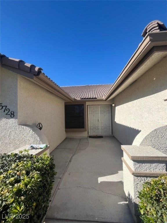 view of exterior entry with a patio